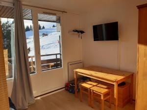 ein kleines Esszimmer mit einem Tisch und einem Fenster in der Unterkunft Ski Soleil 304 in Manigod