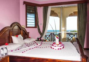 a bedroom with a bed with a wedding cake on it at Watamu Adventist Beach Resort in Watamu