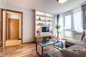 a living room with a couch and a tv at L Rent like home - Panska 3 in Warsaw