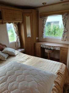 um quarto com uma cama grande e 2 janelas em Domek Holenderski Dzierwany em Wiżajny