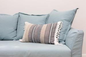 un divano grigio con un cuscino a righe sopra di Rent like home - Twarda 14 a Varsavia