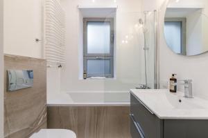 bagno con lavandino, servizi igienici e specchio di Rent like home - Twarda 14 a Varsavia