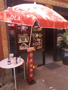 a table and an umbrella in front of a store at Hotel France Ouzoud in Ouzoud