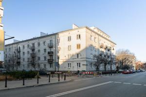 ein großes weißes Gebäude an der Straßenseite in der Unterkunft Rent like home - Nowiniarska 8 in Warschau