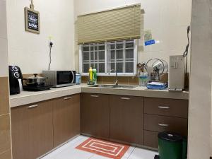 a kitchen with a sink and a microwave at EagleNest at Iris House Resort in Tanah Rata