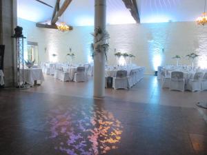 a room with white tables and white chairs and a wall at Château des Monthairons Hôtel Restaurant GastroMaison Spa privatif in Les Monthairons