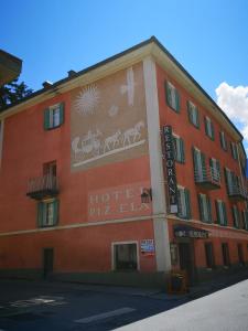 czerwony budynek z napisem na boku w obiekcie Historisches Italienisches Hotel Piz Ela Bergün w mieście Bergün