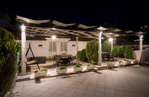 eine Terrasse mit einem Tisch und Stühlen in der Nacht in der Unterkunft Apartments Marija Vukas in Dubrovnik