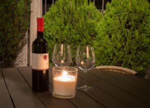 eine Flasche Wein und zwei Weingläser auf dem Tisch in der Unterkunft Apartments Marija Vukas in Dubrovnik