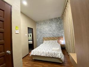 a small bedroom with a bed and a hallway at EagleNest at Iris House Resort in Tanah Rata
