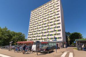 ワルシャワにあるW Rent like home - Grójecka 80102の駐車場車を停めた白い大きな建物