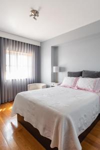 Un dormitorio con una gran cama blanca y una ventana en Avenida Apartment by MP, en Vila Nova de Gaia
