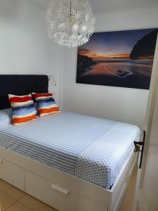 プエルト・デ・ナオスにあるApartamento calasのベッドルーム1室(上にシャンデリア付きのベッド1台付)