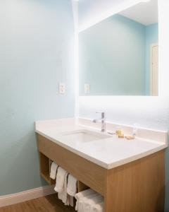 a bathroom with a sink and a mirror at Dunes Inn & Suites - Tybee Island in Tybee Island