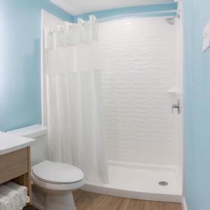 a bathroom with a shower with a toilet and a sink at Dunes Inn & Suites - Tybee Island in Tybee Island