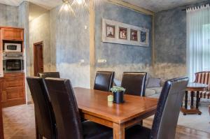 a dining room with a wooden table and chairs at Kőház Apartman in Veszprém