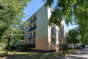 ワルシャワにあるRent like home - Pawia 36の目の前に木々が生い茂るアパートメント