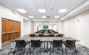 una sala de conferencias con una mesa grande y sillas en Hotel Eleo at the University of Florida, en Gainesville