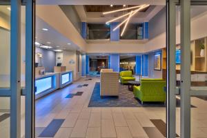 an office lobby with blue walls and green chairs at Holiday Inn Express & Suites - Effingham, an IHG Hotel in Effingham