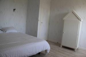 - une chambre avec un lit blanc et une armoire blanche dans l'établissement Leshorizonsperrosguirec, à Perros-Guirec