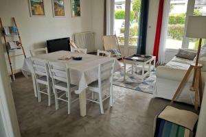 salon z białym stołem i krzesłami w obiekcie Leshorizonsperrosguirec w mieście Perros-Guirec