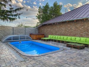 - une piscine avec un canapé et un banc à côté d'un bâtiment dans l'établissement MADISON RANCH, à Szabolcsveresmart