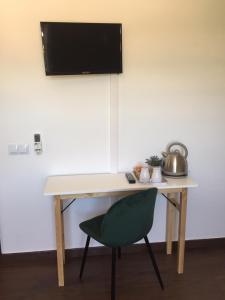 einen Schreibtisch mit Stuhl und einen TV an der Wand in der Unterkunft Ponte Romana in Silves