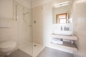 bagno bianco con lavandino e doccia di Göllerhof a Caldaro