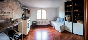 a kitchen and living room with a couch and wooden floors at STUPENDA MANSARDA CENTRALISSIMA, finiture di lusso in Carrara