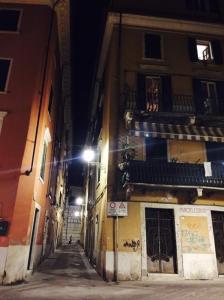 une allée la nuit avec un feu de rue à côté d'un bâtiment dans l'établissement STUPENDA MANSARDA CENTRALISSIMA, finiture di lusso, à Carrara