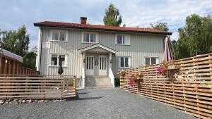 a white house with a fence in front of it at Hovstø Hytter & Rom in Seljord
