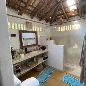 un baño con lavabo y espejo en Casa limão, en Trancoso