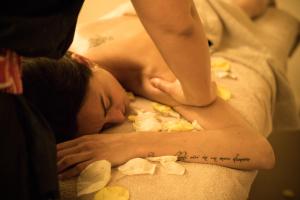 a woman sleeping on a bed with a tattoo on her arm at Blu Suite Resort in Bellaria-Igea Marina