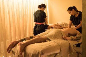 貝拉里亞－伊賈馬里納的住宿－Blu Suite Resort，两个妇女站在病床上的病人身边