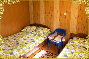 クシュチェフスカヤにあるU Tatyanyの木製の壁の客室で、ベッド2台と椅子が備わります。
