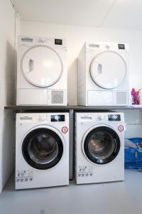 three washing machines and a washer and dryer in a room at aday - Apartment suite 1 Aalborg Center in Aalborg