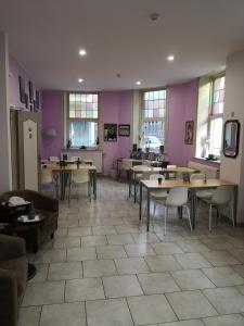 a restaurant with tables and chairs and purple walls at Hôtel Les Acteurs in Liège