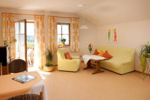 sala de estar con sofá amarillo y mesa en Ferienwohnung Schreiner, en Hohenau