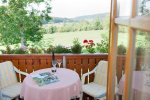 una mesa con una botella de vino y dos sillas en Ferienwohnung Schreiner, en Hohenau