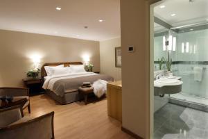 a bedroom with a bed and a bathroom with a sink at Windsor Hotel in Córdoba