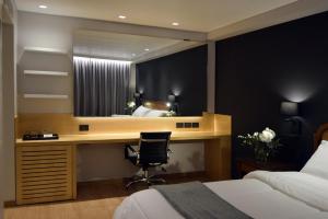 a bedroom with a desk with a mirror and a bed at Windsor Hotel in Córdoba