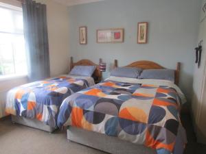 twee bedden naast elkaar in een slaapkamer bij The Yellow Rose B&B in Ballina