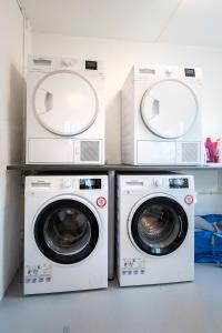 2 Waschmaschinen sowie eine Waschmaschine und ein Trockner in einem Zimmer in der Unterkunft aday - Apartment suite 4 Aalborg Center in Aalborg