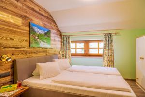 een slaapkamer met een bed en een houten muur bij Putzenhof Appartements in Großkirchheim