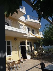 a building with chairs and tables in front of it at Eirini in Neochórion