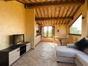 a living room with a couch and a tv and a table at Tuscany Charme Boutique House in Monteroni dʼArbia