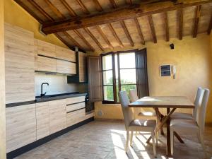 a kitchen with a table and chairs in a room at Tuscany Charme Boutique House in Monteroni dʼArbia