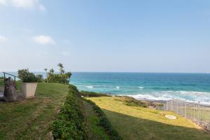 a view of the ocean from a yard at Sea front designer apartment in Ballito