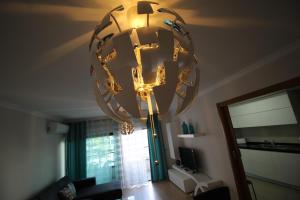 um grande lustre pendurado no tecto numa sala de estar em Rocha Prime Residence em Portimão