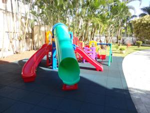 a playground with a slide in a park at Flat Boulevard Riviera de São Lourenço - Praia in Riviera de São Lourenço